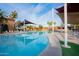 Community pool area featuring covered seating, palm trees, and ample space for relaxation at 15479 W Whitton Ave, Goodyear, AZ 85395