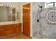 Bathroom featuring a walk-in shower with decorative tile surround and stylish wood cabinetry at 16029 N 36Th Dr, Phoenix, AZ 85053