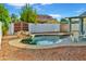 Backyard pool surrounded by desert landscaping featuring rock waterfall, white lounge chairs, and grassy area at 16029 N 36Th Dr, Phoenix, AZ 85053