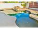 Sparkling pool with a rock waterfall feature, surrounded by a well-maintained patio and lush landscaping at 16029 N 36Th Dr, Phoenix, AZ 85053