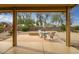 Covered patio with outdoor seating, offering a serene view of the beautifully landscaped backyard with desert plants at 16051 W Desert Winds Dr, Surprise, AZ 85374