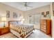 Cozy bedroom with a ceiling fan, neutral walls, and warm lamps on each bedside table at 16051 W Desert Winds Dr, Surprise, AZ 85374