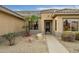 Inviting entryway with decorative security door and meticulously maintained desert landscaping with gravel at 16051 W Desert Winds Dr, Surprise, AZ 85374