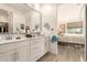 Stylish bathroom with double sinks, a large mirror, and a view to the bedroom at 16593 W Alameda Rd, Surprise, AZ 85387