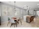 Open dining area featuring a stylish round table and modern light fixture, seamlessly connected to the kitchen island at 1677 E Bridgeport Pkwy, Gilbert, AZ 85295