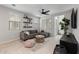 A cozy living room with a modern ceiling fan, plush gray sectional, and stylish decor at 1677 E Bridgeport Pkwy, Gilbert, AZ 85295