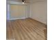 Bright living room featuring wood floors, a ceiling fan, and sliding door with vertical blinds at 17017 N 12Th St # 1135, Phoenix, AZ 85022