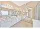 Bathroom featuring double sinks, white cabinetry, a soaking tub, and glass-enclosed shower at 17036 N 43Rd Pl, Phoenix, AZ 85032