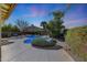 Backyard oasis at twilight showcasing a sparkling pool with lush landscaping and mature trees at 17036 N 43Rd Pl, Phoenix, AZ 85032