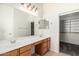 Bright bathroom with a double sink vanity, large mirror, and a walk-in closet, creating a functional space at 17642 W Pershing St, Surprise, AZ 85388