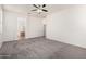 Spacious bedroom featuring neutral carpet, a ceiling fan, access to the Primary bath, and plenty of natural light at 17642 W Pershing St, Surprise, AZ 85388