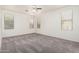 Spacious bedroom featuring neutral carpet, a ceiling fan, three large windows, and plenty of natural light at 17642 W Pershing St, Surprise, AZ 85388