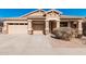 Inviting single-story home featuring a desert landscape, covered porch, and attached garage at 17642 W Pershing St, Surprise, AZ 85388