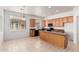 Kitchen featuring an island with granite countertops, tile flooring, wood cabinets, and stainless steel appliances at 17642 W Pershing St, Surprise, AZ 85388