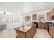 Kitchen with granite countertops, tile flooring, wood cabinets and an island open to an adjacent room at 17642 W Pershing St, Surprise, AZ 85388