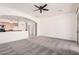 Bright living room with neutral carpet, an open layout, and sliding glass doors to the backyard at 17642 W Pershing St, Surprise, AZ 85388