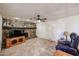 Spacious living room featuring a stone fireplace, tile flooring, and a ceiling fan with light fixture at 19013 N 18Th Ave, Phoenix, AZ 85027