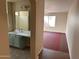 Bathroom view featuring a vanity with double sinks, framed mirror, and a connecting doorway to the bedroom at 2016 S 66Th Ln, Phoenix, AZ 85043