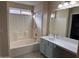 Bathroom view featuring a shower-tub combo, a vanity with a sink, and a large framed mirror at 2016 S 66Th Ln, Phoenix, AZ 85043