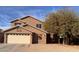 Charming two-story home featuring a tan stucco exterior, a two-car garage, and desert landscaping at 2016 S 66Th Ln, Phoenix, AZ 85043