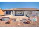 A charming covered back patio features terracotta pots, red rock landscaping, and a retractable awning at 21614 N 138Th Ave, Sun City West, AZ 85375