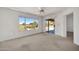 Bright bedroom with a ceiling fan, carpet, large windows, and a sliding glass door at 21614 N 138Th Ave, Sun City West, AZ 85375