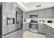 Modern kitchen featuring stainless steel appliances and gray cabinets at 21614 N 138Th Ave, Sun City West, AZ 85375