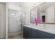 Beautiful bathroom featuring a double sink vanity and glass enclosed shower with pebble floor at 2168 E Vista Bonita Dr, Phoenix, AZ 85024