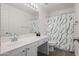 Bathroom with a single sink vanity, a large mirror, and a shower with green patterned curtain at 2168 E Vista Bonita Dr, Phoenix, AZ 85024