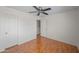 Bedroom with wood floors, ceiling fan, closet, and a door to the hallway at 2168 E Vista Bonita Dr, Phoenix, AZ 85024