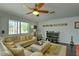 Comfortable living room featuring a plush sofa, ceiling fan, and large window with outdoor views at 2168 E Vista Bonita Dr, Phoenix, AZ 85024