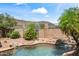 Beautiful pool with rock waterfall feature, cactus, and desert landscaping at 2168 E Vista Bonita Dr, Phoenix, AZ 85024