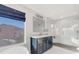 Elegant bathroom showcasing navy vanity, quartz countertop, modern mirror, and a sleek glass-enclosed shower at 21915 N 65Th Ave, Glendale, AZ 85310