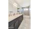 Bathroom featuring double sinks with granite countertops, neutral paint, and tile floors at 21915 N 65Th Ave, Glendale, AZ 85310