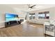 Sunlit living area features wood floors, fireplace, ceiling fan, and expansive views of the outdoor scenery at 21915 N 65Th Ave, Glendale, AZ 85310