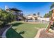 Expansive backyard featuring a refreshing pool, a large grass area, and a charming two-story home at 24021 N 39Th Ln, Glendale, AZ 85310