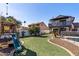 This backyard includes a play structure and a well-maintained artificial grass and a two-story home at 24021 N 39Th Ln, Glendale, AZ 85310