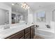 Bathroom featuring dual sinks, shower with glass door, and bathtub at 25268 N 142Nd Dr, Surprise, AZ 85387