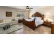 Bedroom with ceiling fan, a large ornate wood bed, sitting area, and view from the window at 25621 N Cordova Ln, Rio Verde, AZ 85263