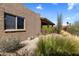 View of the home exterior with lush landscaping and a covered patio area at 25621 N Cordova Ln, Rio Verde, AZ 85263