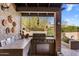 Outdoor kitchen area featuring a built in grill, countertop space, storage, and desert views at 25621 N Cordova Ln, Rio Verde, AZ 85263