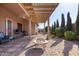 Inviting covered patio with brick pavers, a cozy fire pit, BBQ, and views of the landscaped backyard at 2854 S Berrywood --, Mesa, AZ 85212