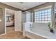 Bright bathroom shows glass block window by tub and an open doorway to the main bedroom at 29740 W Fairmount Ave, Buckeye, AZ 85396