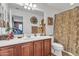 Neutral bathroom with white sink, wooden vanity, decor and shower with curtains at 29740 W Fairmount Ave, Buckeye, AZ 85396