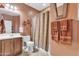 Neutral bathroom with white sink, wooden vanity and shower with curtains at 29740 W Fairmount Ave, Buckeye, AZ 85396