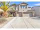 Two story stucco home with a three car garage, desert landscaping, and a large palm tree at 29740 W Fairmount Ave, Buckeye, AZ 85396