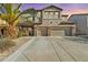 Two story stucco home with a three car garage, desert landscaping, and a large palm tree at 29740 W Fairmount Ave, Buckeye, AZ 85396