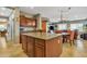 Open kitchen featuring a central island, wooden cabinets, and seamless flow into the adjacent dining and living areas at 29740 W Fairmount Ave, Buckeye, AZ 85396