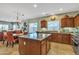 Open kitchen features a central island, modern appliances, and blends into the dining area with a stylish chandelier at 29740 W Fairmount Ave, Buckeye, AZ 85396