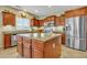 Spacious kitchen with cherry wood cabinets, stainless steel appliances, and center island at 29740 W Fairmount Ave, Buckeye, AZ 85396